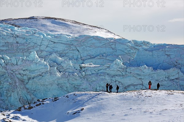 People in front of the break-off edge of the Russell Glacier