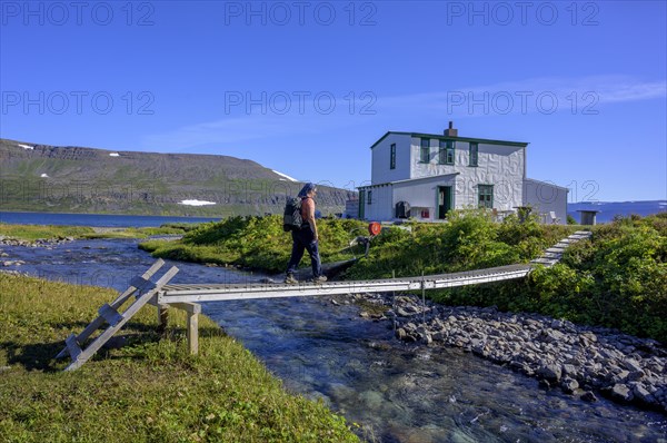 Woman walking over footbridge at Doctor's house or Laeknishusio