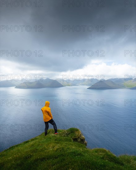 Person looking at the sea and the island of Eysturoy