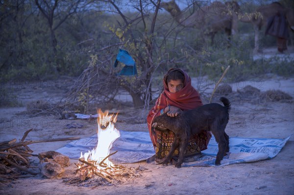 Fakirani next to a wood fire camp in the early morning