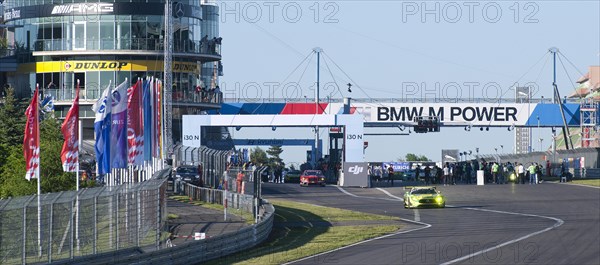 Race cars drive out of Nuerburgring race track pit lane