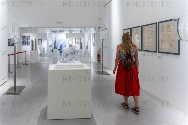 Young woman in the glass museum looking at hand-blown glass