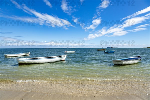 Fishing boats in turquoise green water on the beach at Bain des Dames