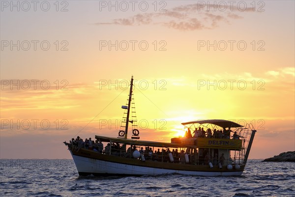 Tourist boat in the sea at sunset