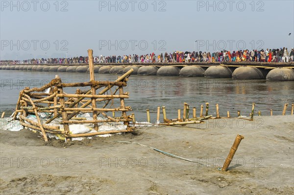 Pilgrims cross the Ganges on a makeshift pontoon bridge