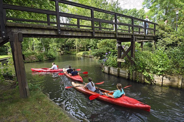 Tourists paddle through the village of Lehde