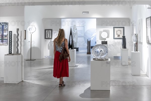 Young woman in the glass museum looking at hand-blown glass