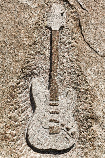 Memorial stone with relief of an electric guitar by Jimi Hendrix