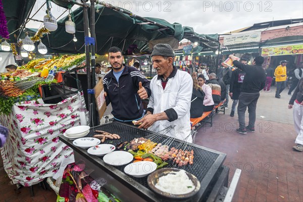 Locals grilling meat kebabs at a food stall