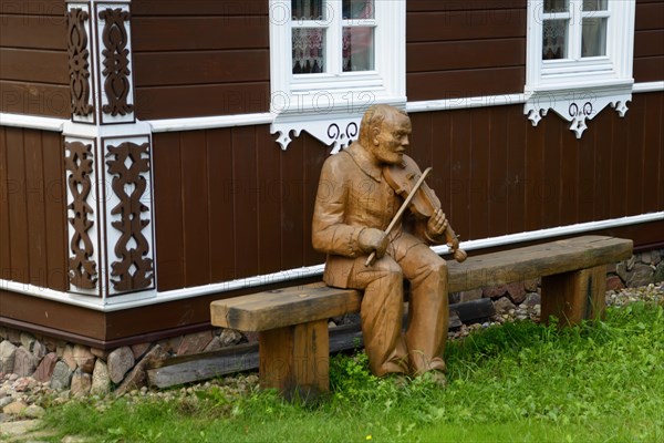 Wooden musician in front of house