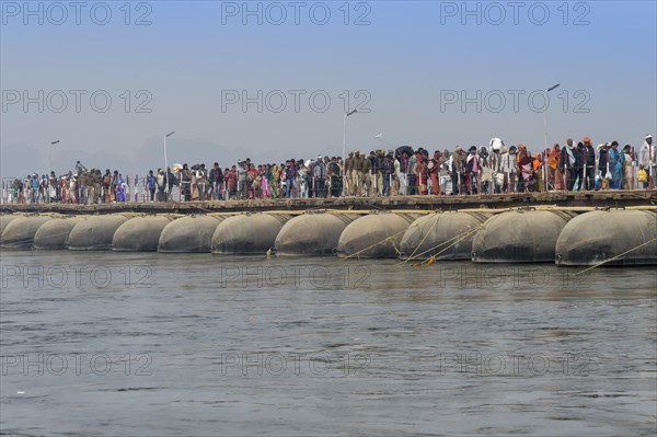 Pilgrims cross the Ganges on a makeshift pontoon bridge