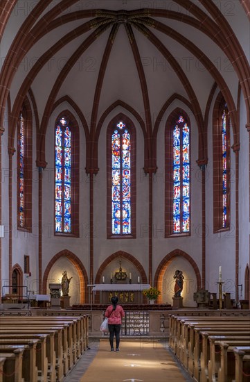 A woman stands devoutly in junglefowl (Gallus) Catholic Church