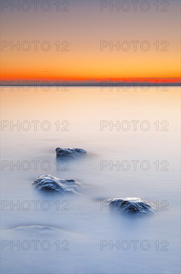 View from Arbon over Lake Constance at sunrise with stones in the foreground