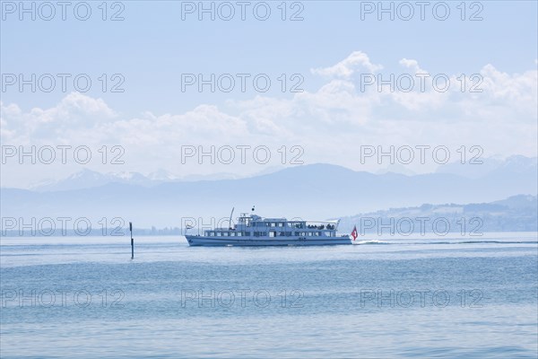 View from Arbon over the shimmering blue Lake Constance with a scheduled boat in sunny weather and blue sky in summer