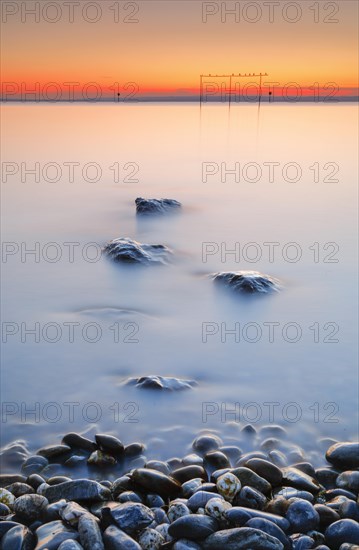 View from Arbon over Lake Constance at sunrise with stones in the foreground