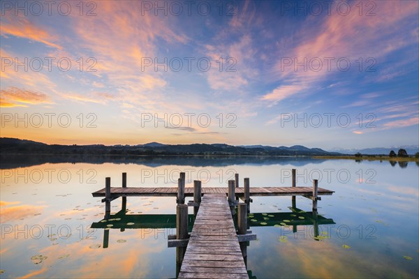 Wooden footbridge on Lake Pfaeffikon at sunrise