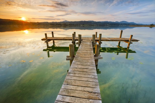 Wooden footbridge on Lake Pfaeffikon at sunrise