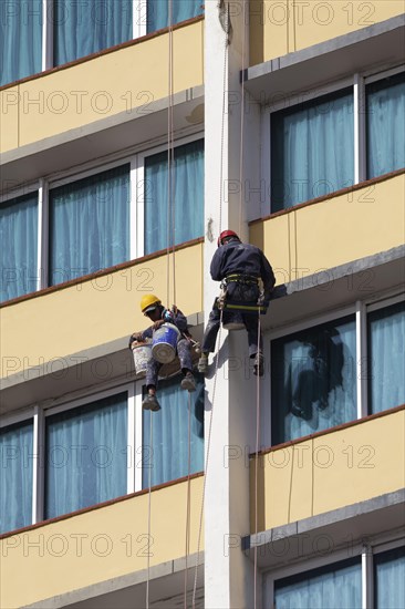 Two facade climbers hanging from a rope