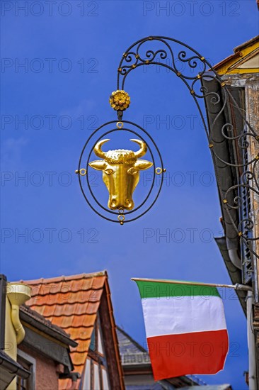 Guild sign of the Gasthof Zum Ochsen above an Italian national flag in Ladenburg