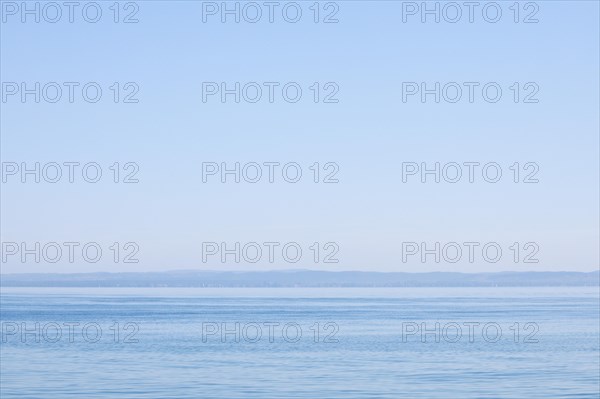 View from Arbon over blue shimmering Lake Constance in sunny weather and blue sky in summer