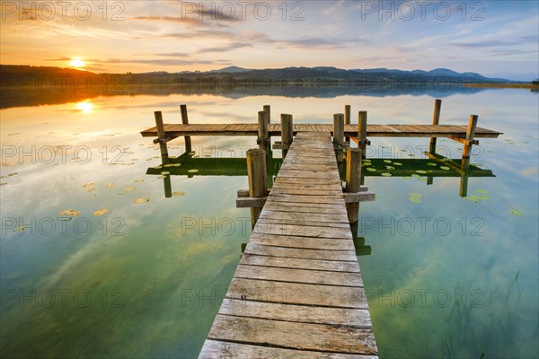 Wooden footbridge on Lake Pfaeffikon at sunrise