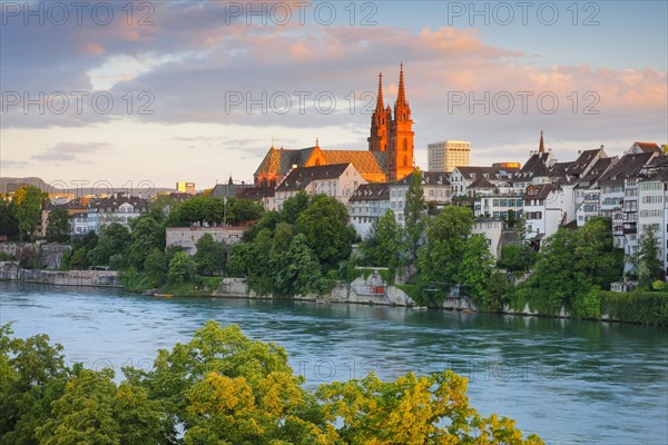 View of the Basel Cathedral in the middle of the old town of Basel with the turquoise Rhine River in the foreground