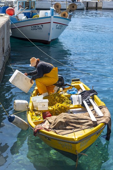 Fishermen on a small rowing boat in the harbour of Livadia on the island of Tilos