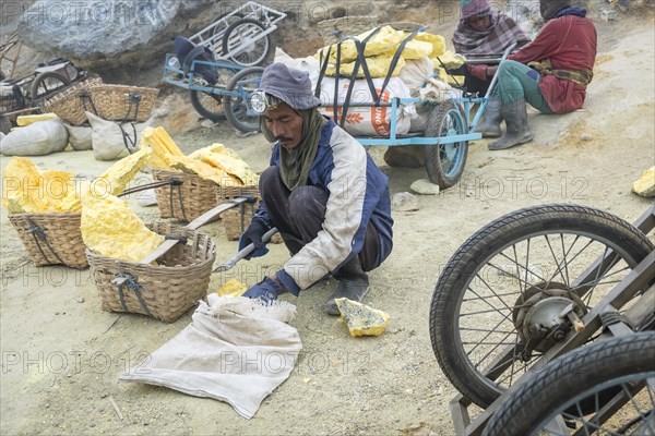 Sulphur worker crushing sulphur