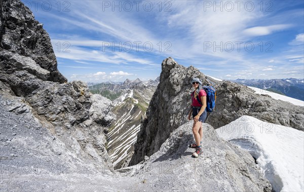 Hiker on a rock while climbing to the summit Maedelegabel