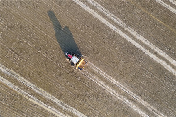 Tractor sowing rice seeds in a flooded rice field in May