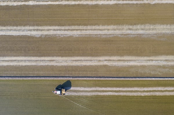 Tractor sowing rice seeds in a flooded rice field in May