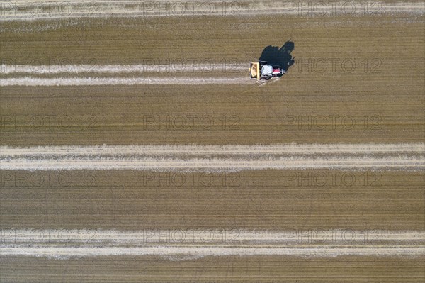 Tractor sowing rice seeds in a flooded rice field in May