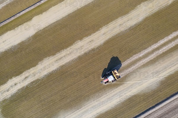 Tractor sowing rice seeds in a flooded rice field in May