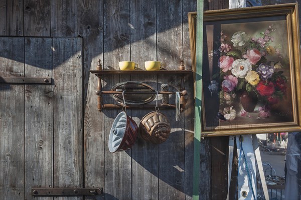 Paintings and bric-a-brac on old wooden wall