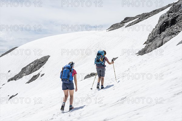 Two hikers on old snowfield