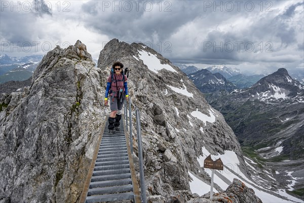 Hiker on a metal bridge on a rock