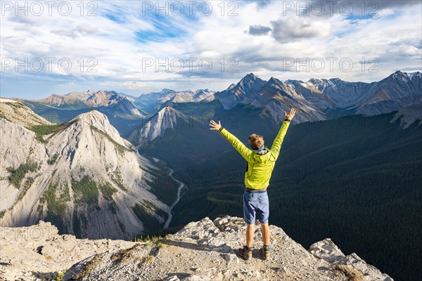 Hiker stretches his arms in the air