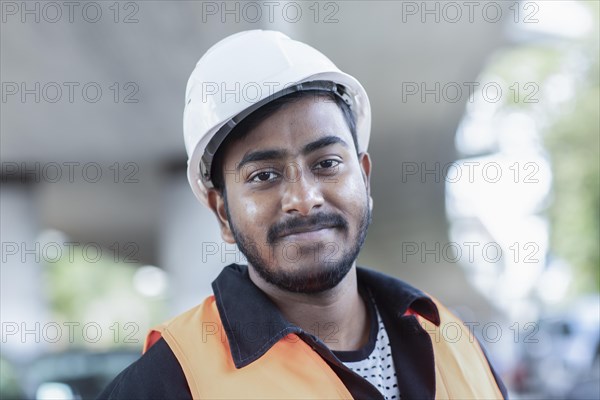 Young technician with beard outside with helmet working on a bridge