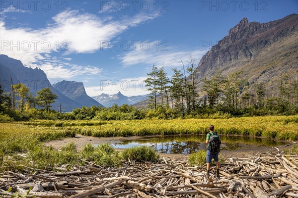 Hikers at a small pond on washed-up wood