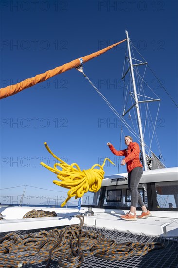 Young woman throws a rope on deck