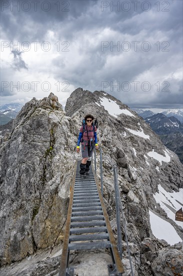 Hiker on a metal bridge on a rock