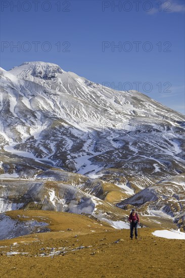 Woman in front of snowy mountains Fannborg and Snaekollur in the hot spring area Hveradalir