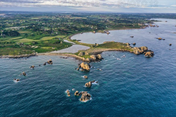 Wide angle drone shot from the Atlantic Ocean onto the granite coast of Plougrescant with a view of the house between the rocks (Le gouffre de Plougrescant)