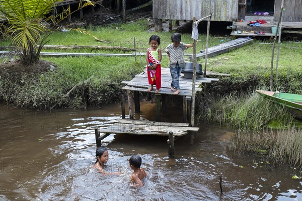 Children in the jungle village playing in the river