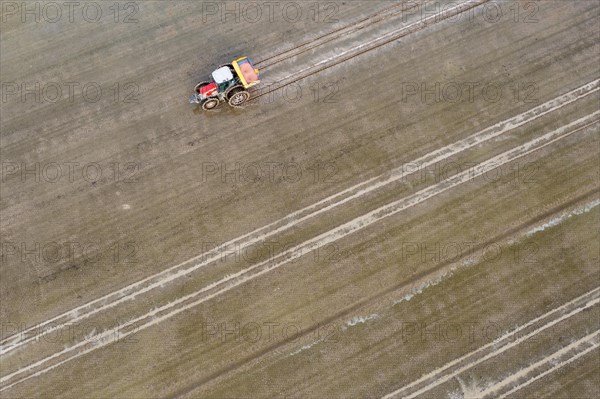 Tractor sowing rice seeds in a flooded rice field in May