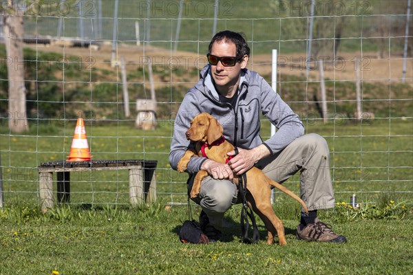 Vizsla puppy and owner in dog school