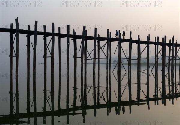 People walk on the U Bein bridge over Taungthaman Lake in Amarapura near Mandalay