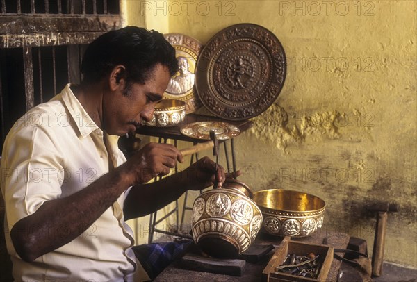 Craftsman works on metal vessel