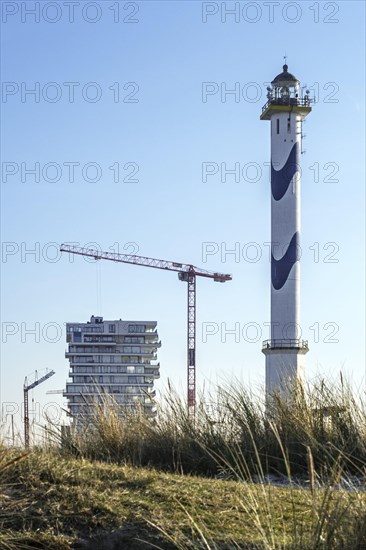 Lange Nelle lighthouse and new flats under construction for the Oosteroever real estate project in the port of Ostend on the Belgian North Sea coast