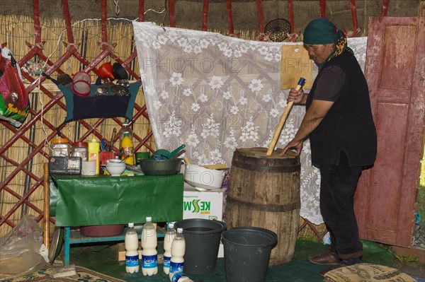 Kyrgyz woman mixing kumis during the fermentation process